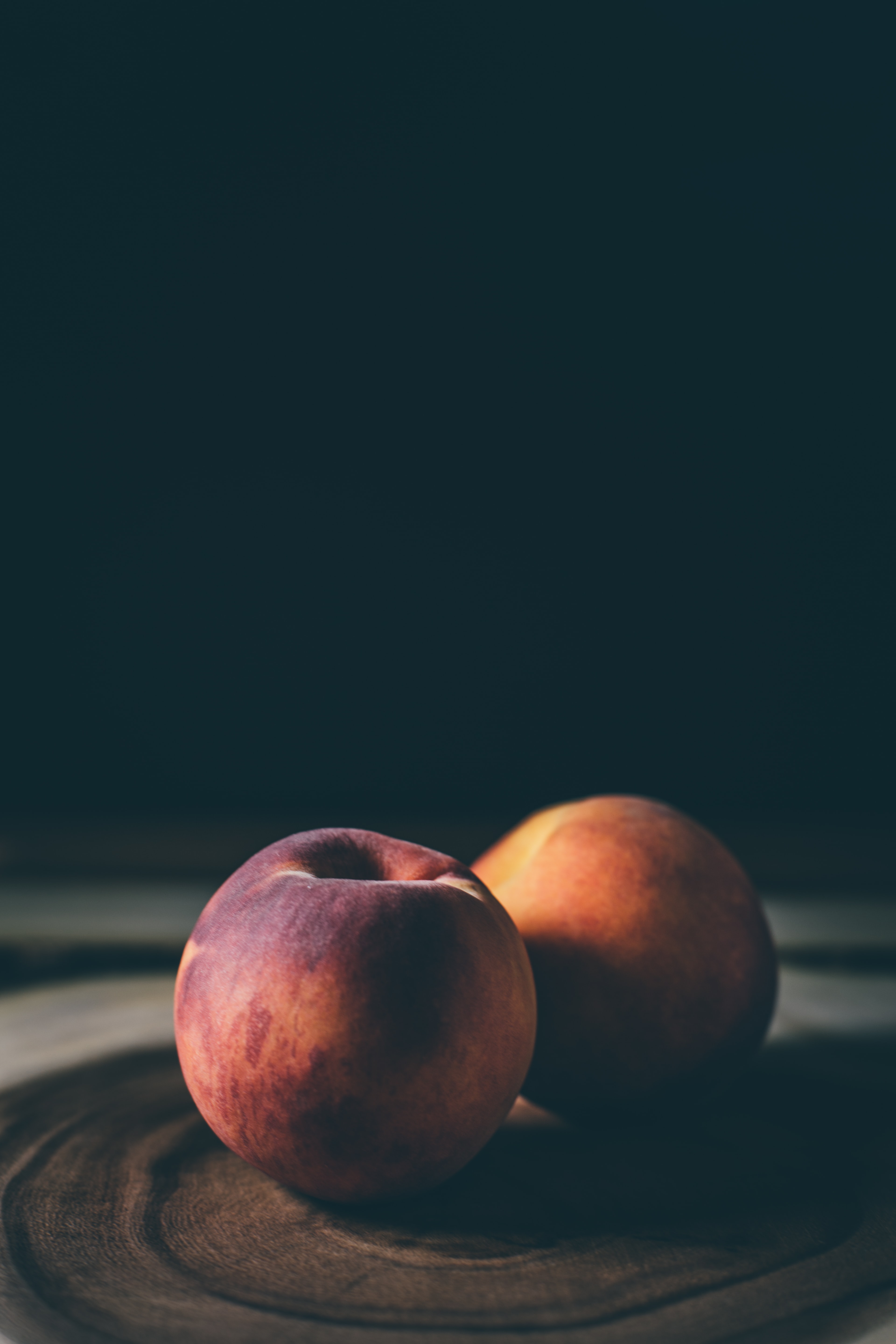 two peaches on a black background